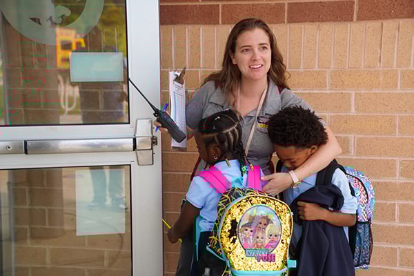 teacher and students entering school
